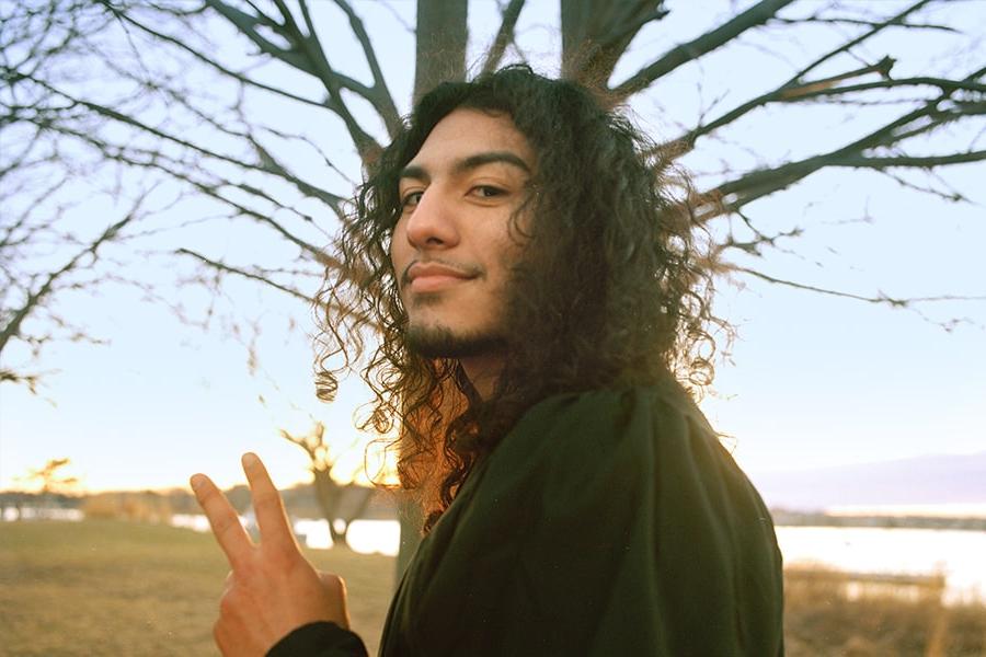 Student makes peace symbol with hand facing camera.